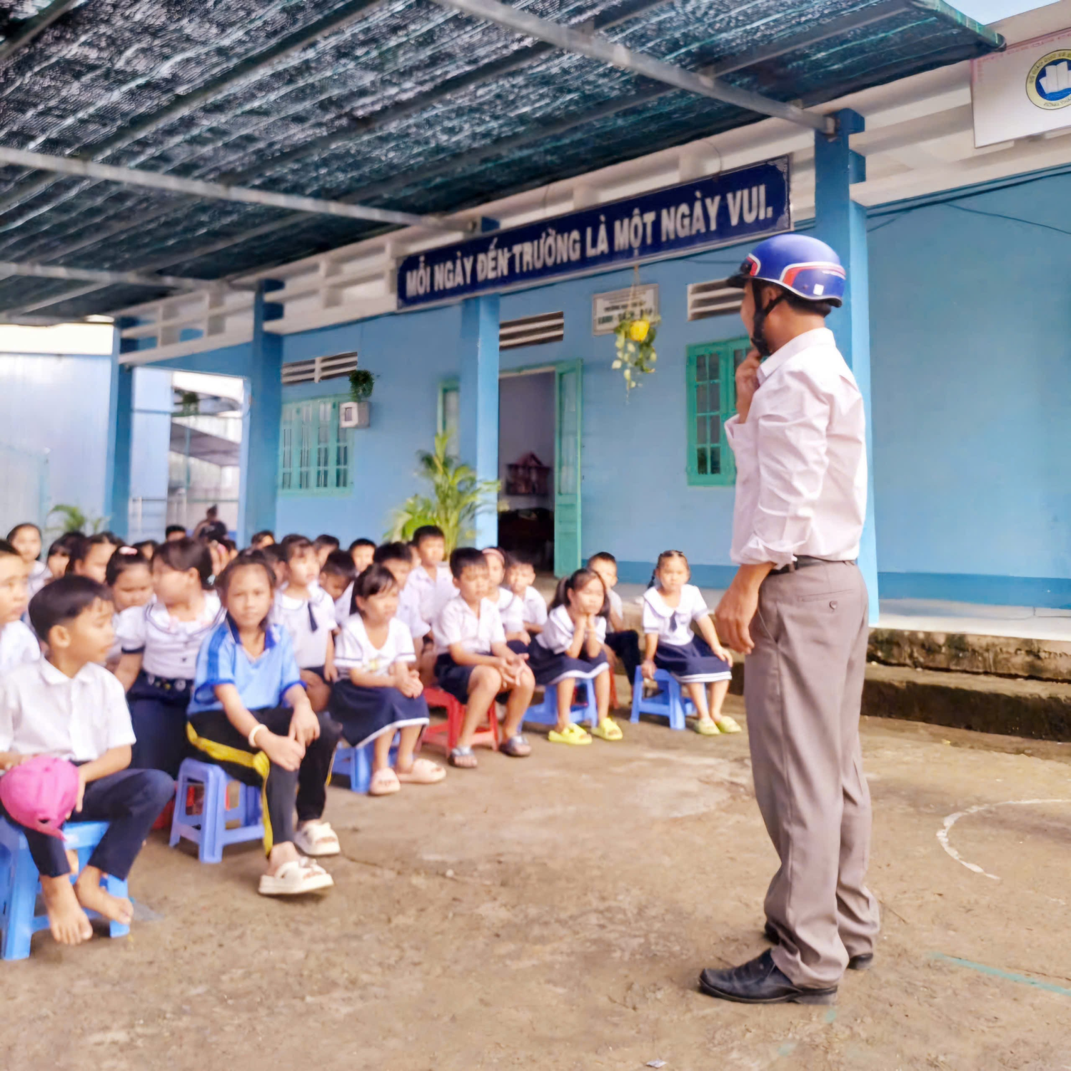 Giáo viên hướng dẫn học sinh đội mũ bảo hiểm đúng cách